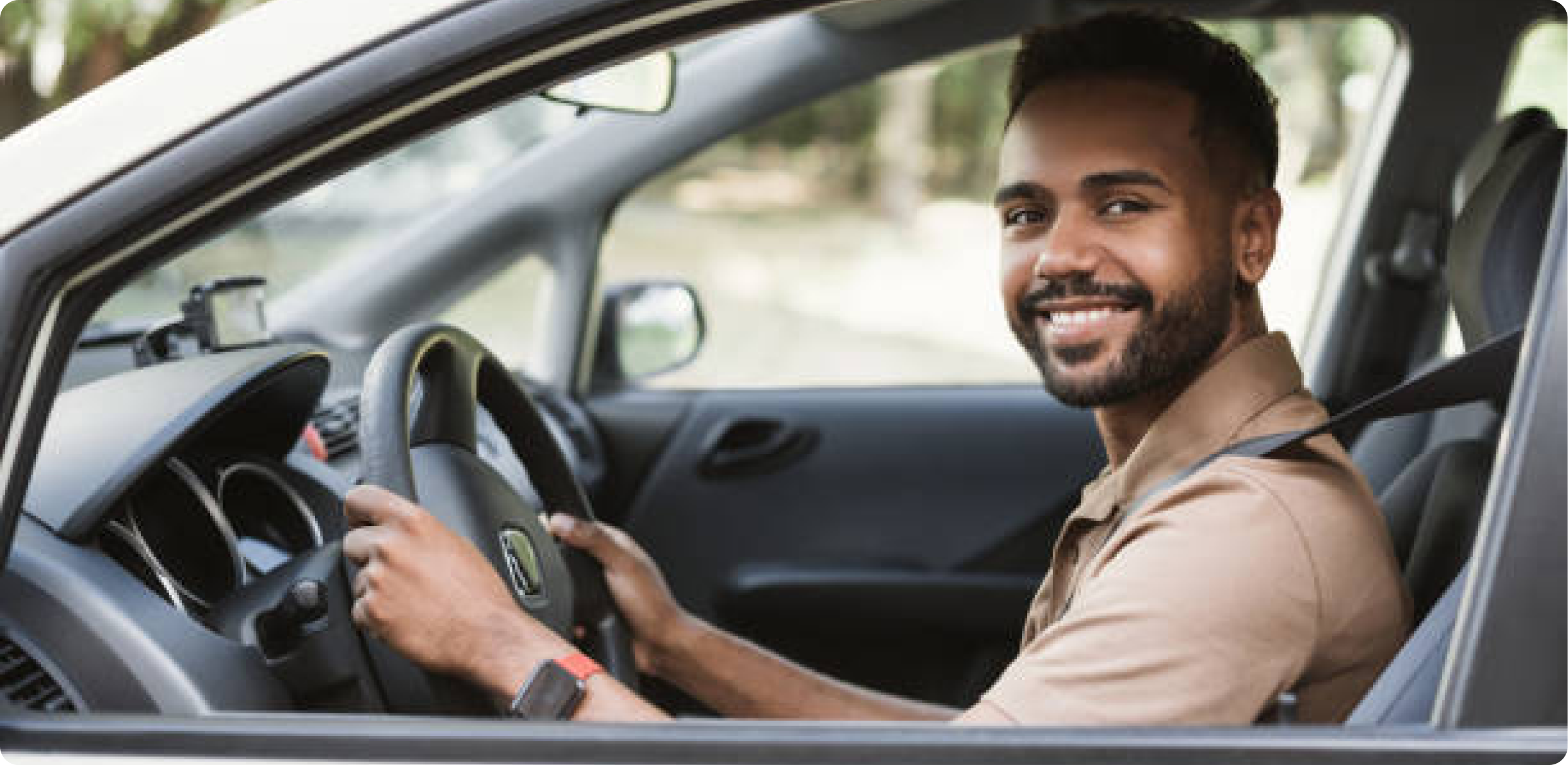 um homem moreno dirigindo um carro